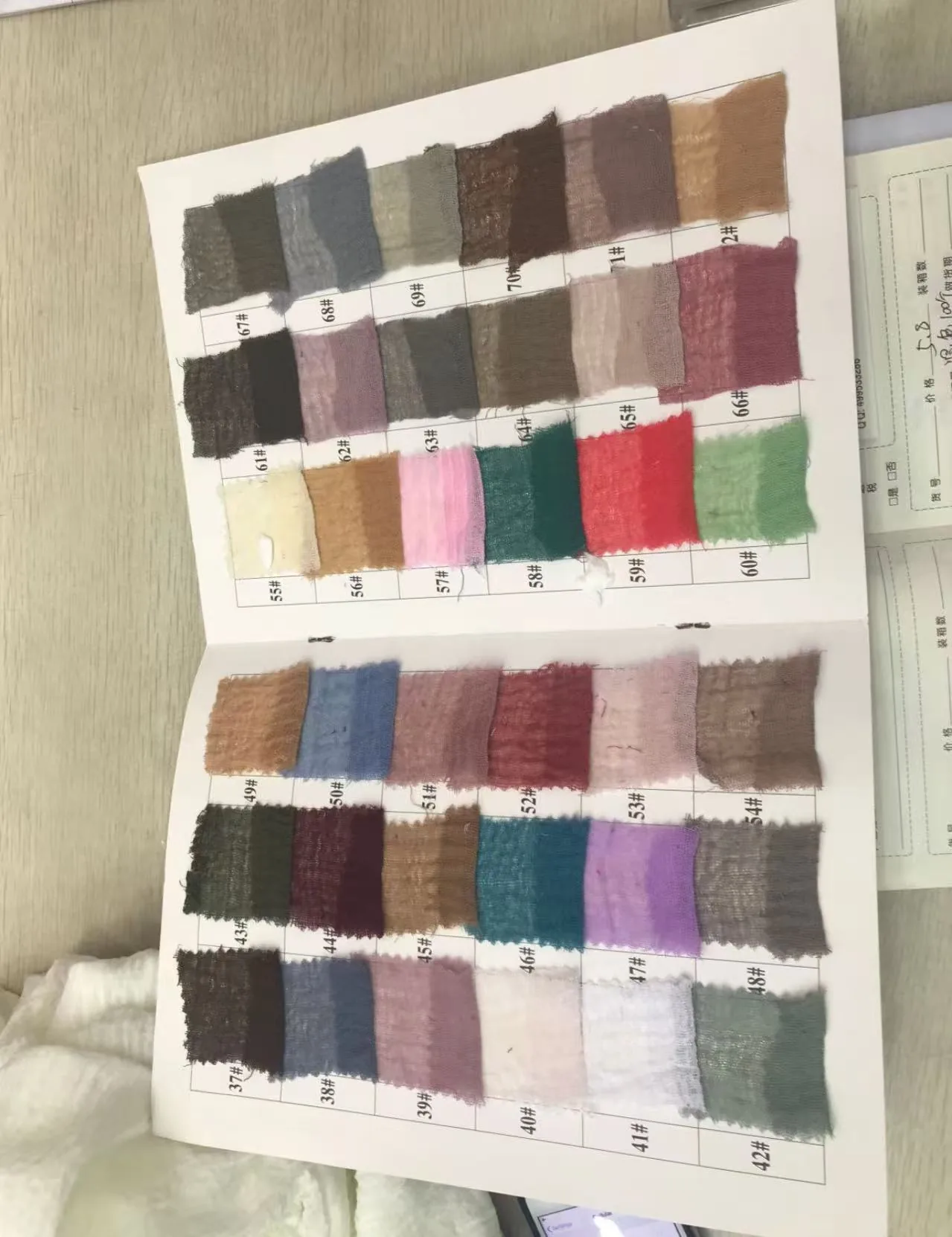 Fabric colour swatch samples laid out next to an order sheet at a Chinese textile supplier