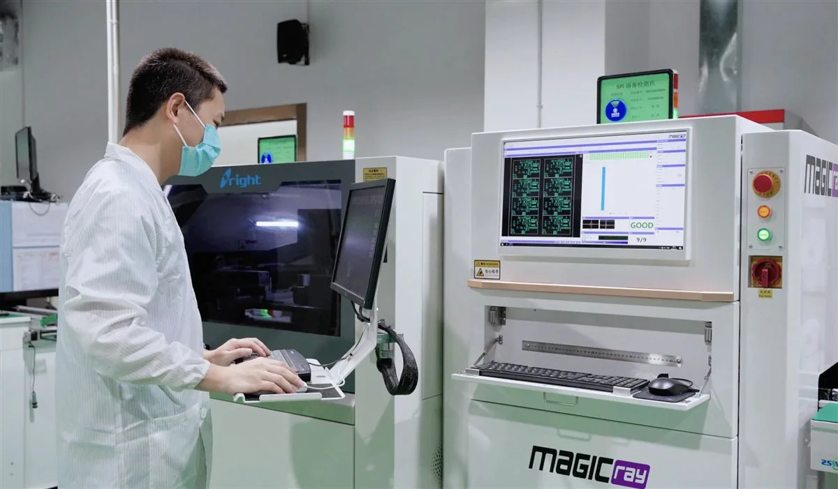 Quality inspector reviewing automated electronic production test results at a factory in China