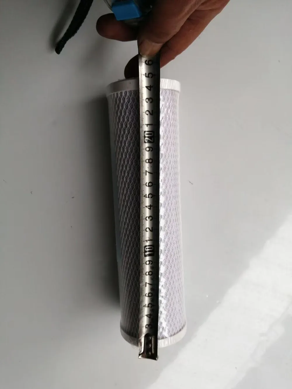 Complete height measurement showing the full filter component, tape starting point and final reading